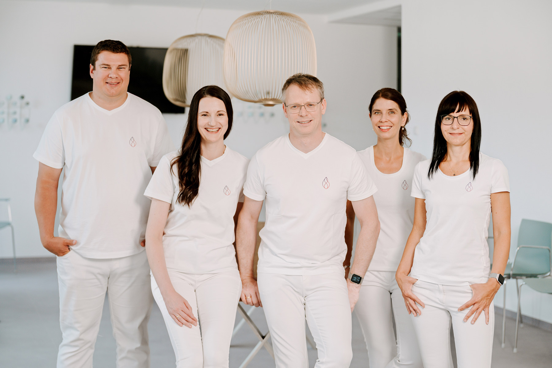 Team der Herzpraxis Magdeburg in weißer Kleidung, freundlich lächelnd im modernen Praxisumfeld.
