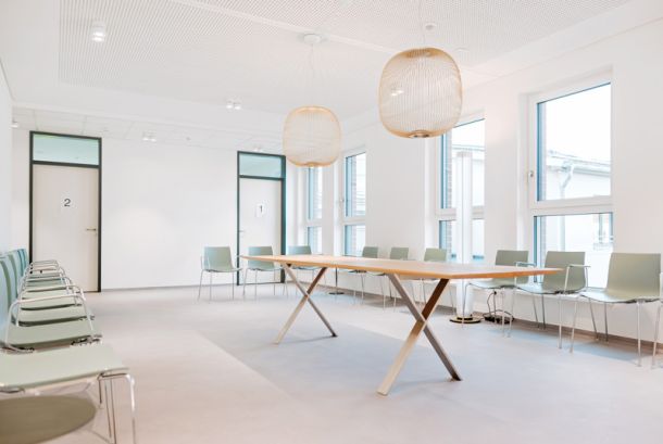 Heller Wartebereich der Herzpraxis Magdeburg mit modernen Stühlen, großem Tisch und freundlicher Atmosphäre.