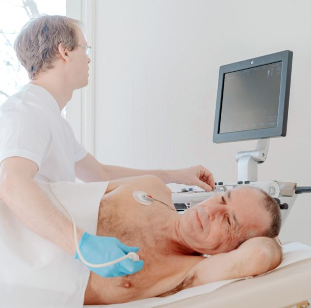 Arzt der Herzpraxis Magdeburg führt eine Herzultraschall-Untersuchung bei einem Patienten durch.