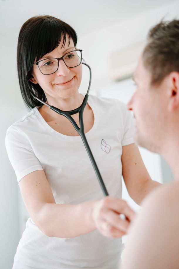 Ärztin der Herzpraxis Magdeburg hört mit Stethoskop den Herzschlag eines Patienten ab – einfühlsame Untersuchung.